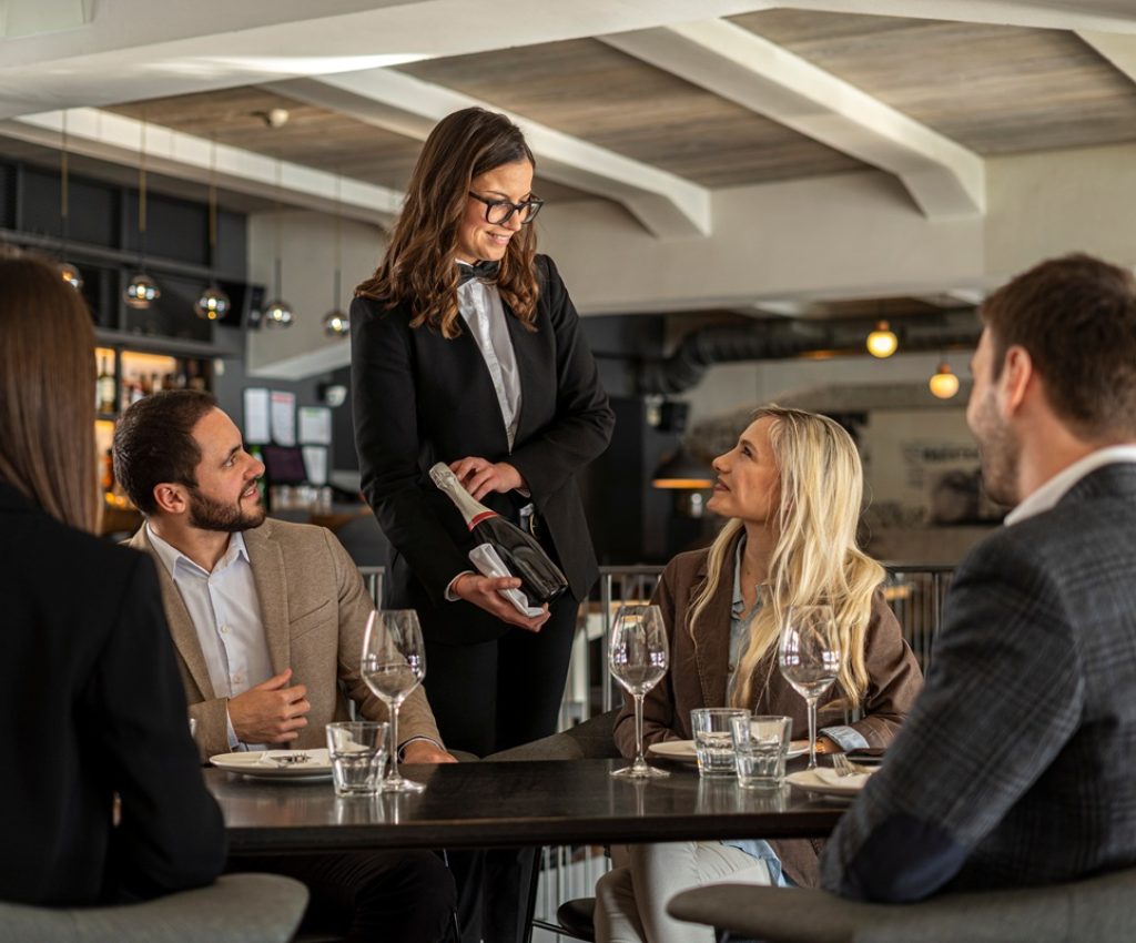 Server,Presenting,Champagne,To,A,Group,Of,People,At,A